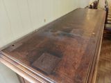 a wooden table with a glass top in the middle of a room