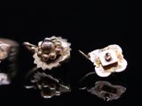 two rings and a ring with a flower on a black surface