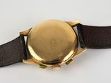 a close up of a watch on a white surface