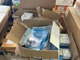 Des cartons contenant du matériel électronique sont empilés sur une palette dans un entrepôt