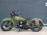 a green motorcycle parked in front of a garage door