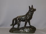 statue of a german shepherd dog on a rock on a white background