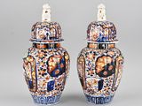pair of blue and white vases with figures on them on a gray background