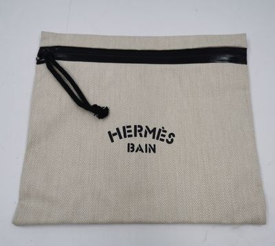 un sac blanc muni d'une fermeture éclair noire et d'un logo