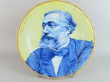 une photo d'une assiette bleue et jaune sur laquelle figure l'image d'un homme en smoking