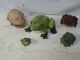 plusieurs figurines de grenouilles et un crâne sur un fond blanc