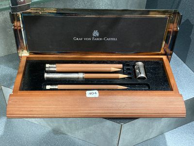 une boîte en bois contenant deux stylos et un crayon