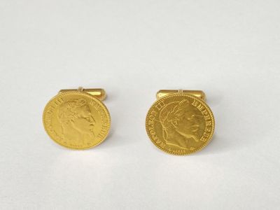a pair of gold coin cufflinks on a white surface