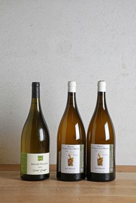 trois bouteilles de vin sont alignées sur une table en bois