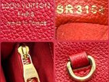 the inside of a red handbag with a gold handle