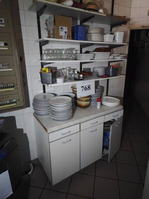 une cuisine avec beaucoup de vaisselle sur le comptoir