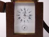 a small brown clock with roman numerals on it