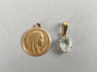 a close up of a small gold medal and a small pendant