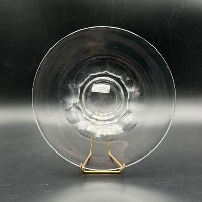 un verre transparent avec une anse dorée posé sur une table