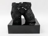 black sculpture of a pair of boots on a black box