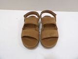 tan sued sandals with straps and buckles on a white surface
