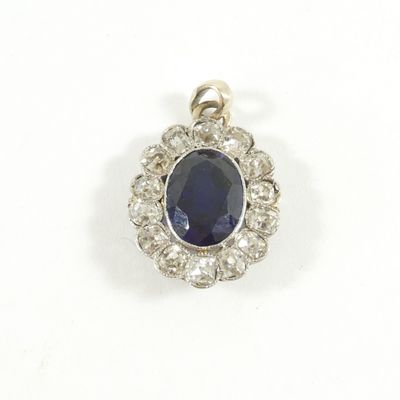 un gros plan d'un pendentif en saphir et diamants sur fond blanc