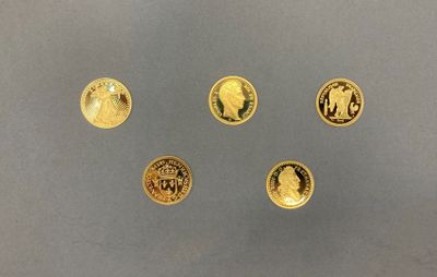 quatre types différents de pièces d'or sur une surface grise