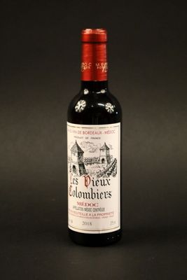 a bottle of red wine sitting on top of a black table