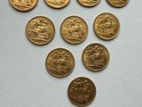 a close up of a bunch of gold coins on a white surface