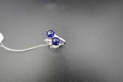 a ring with a blue stone on it on a table