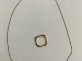 un gros plan d'un collier en or orné d'un pendentif carré