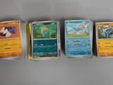 Quatre cartes Pokémon différentes sont alignées sur une table