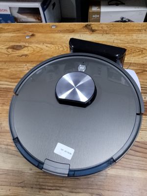 a close up of a robot vacuum sitting on a wooden table
