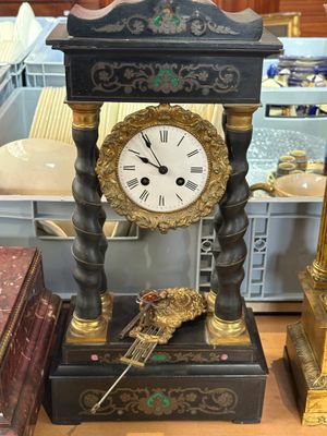 a black and gold clock sitting on top of a table