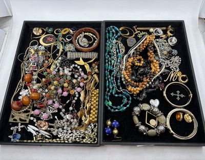 deux plateaux de bijoux posés sur une table