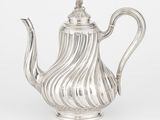 une théière ancienne en argent, ornée d'un motif ondulé sur le couvercle