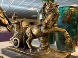 a statue of a horse pulling a cart with a man on it