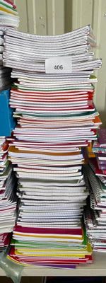 une pile de papiers posée sur un bureau, à côté d'une chaise