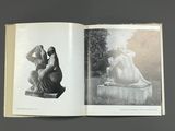 a book opened to show a black and white photo of a woman and a statue