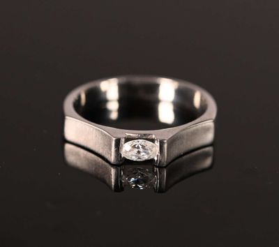 a close up of a ring with a diamond on a black surface