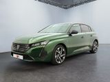 La voiture verte est garée dans une grande pièce aux murs blancs.