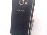 a broken samsung phone sitting on top of a stand