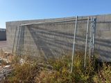 une clôture située à côté d'un bâtiment surmonté d'une clôture