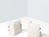 une paire de boucles d'oreilles en forme de cubes de marbre blanc posées sur une surface blanche
