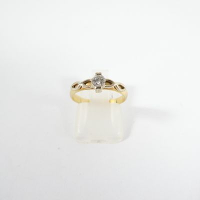 a yellow gold ring with a diamond on top of it