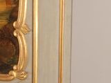 a gold and white cabinet with a painting on the door