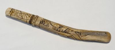 un bâton en bois orné de sculptures, posé sur une table