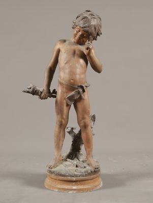 statue en bronze représentant un garçon avec un chien, posée sur un socle