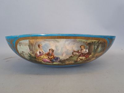 a blue bowl with a painting on it on a table