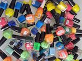 une pile de flacons de vernis à ongles colorés posés sur une table