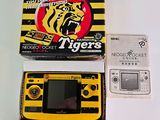 a yellow and black tiger handheld game in a box