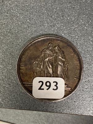 a silver coin with a picture of two people on it