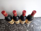 four bottles of wine are lined up on a table