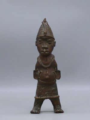 an old bronze figurine of a man with a hat on his head