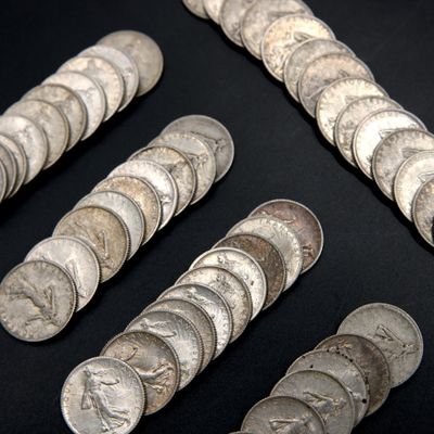 some silver coins are arranged in a row on a black surface